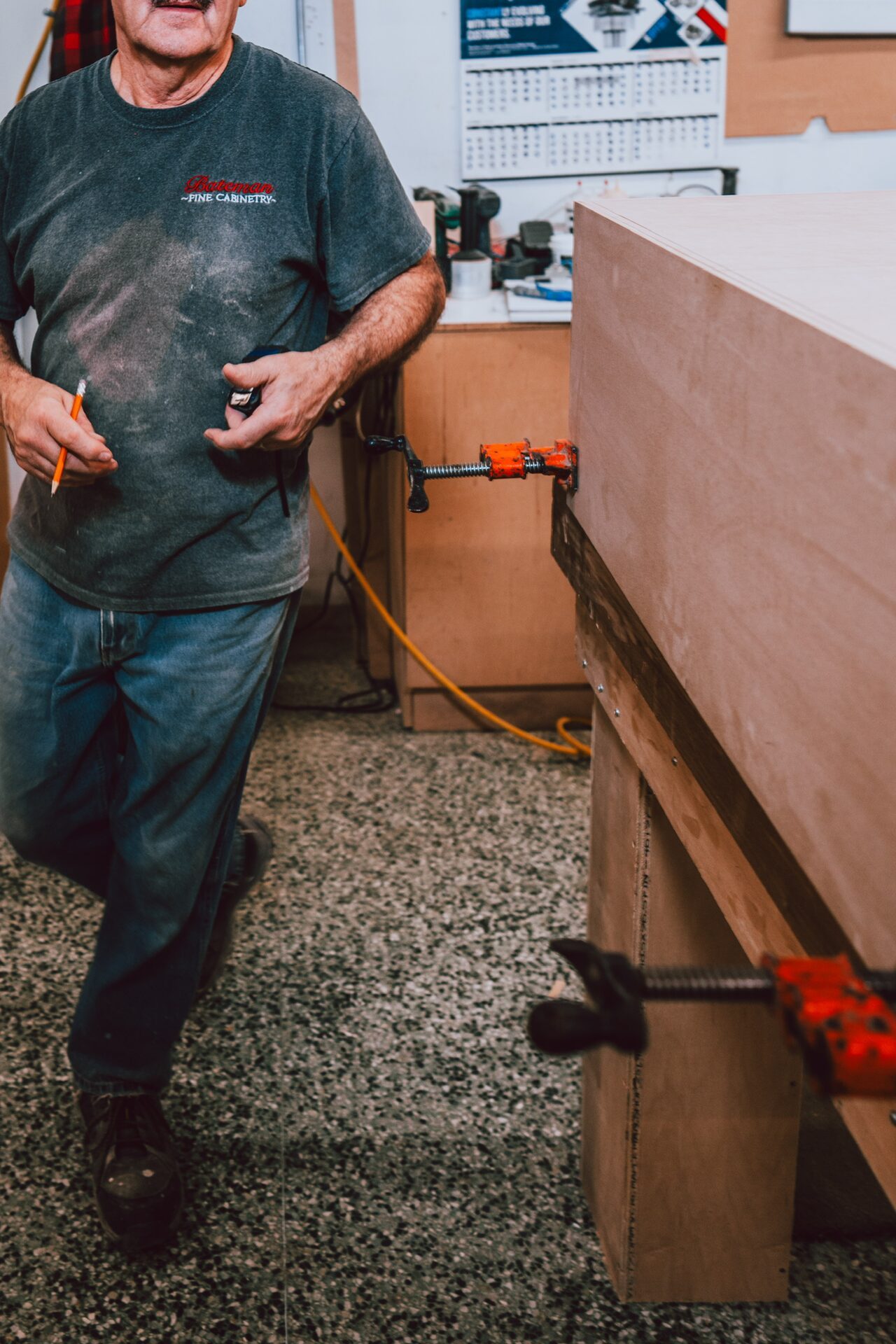 Craftsman at workbench with clamps in the Bateman workshop