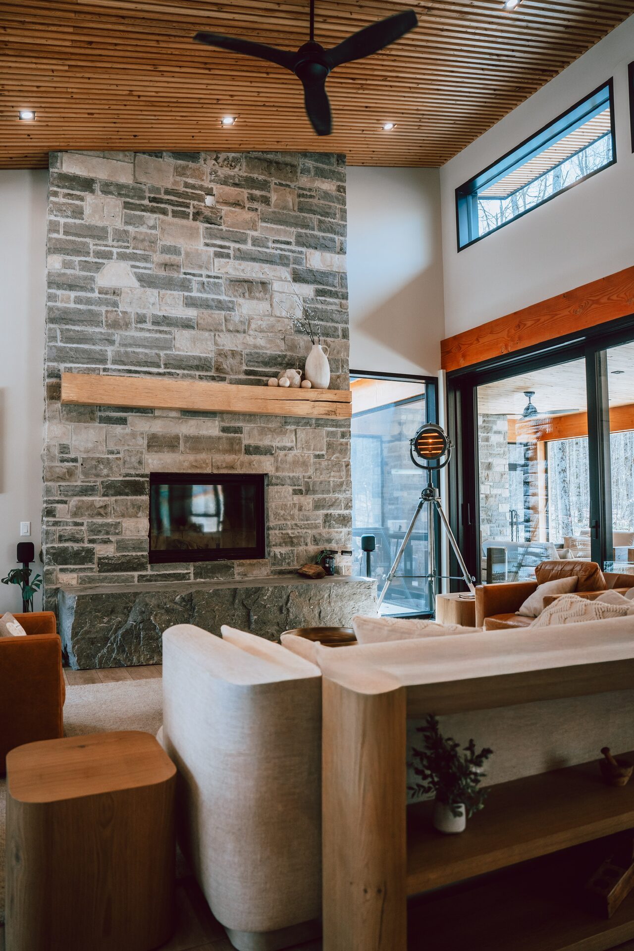 Living room with stone fireplace and wood ceiling